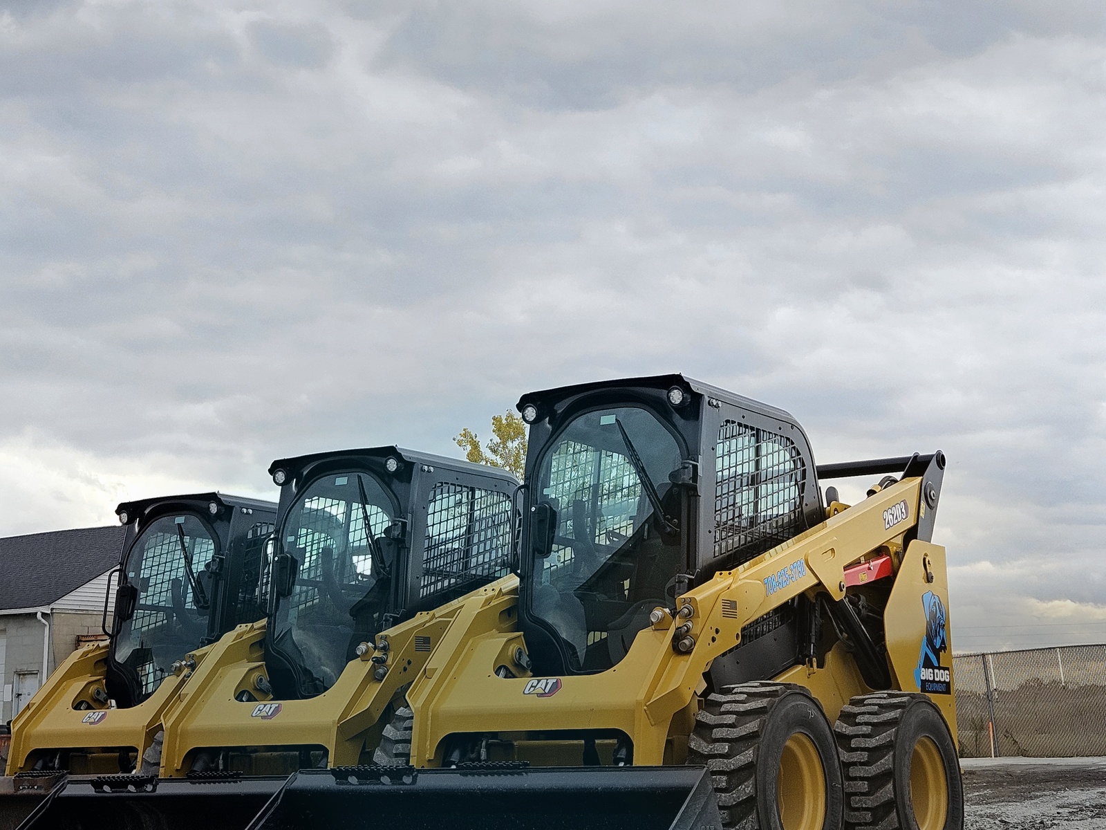Three Big Dog Equipment CAT skid steers lined up and ready for work